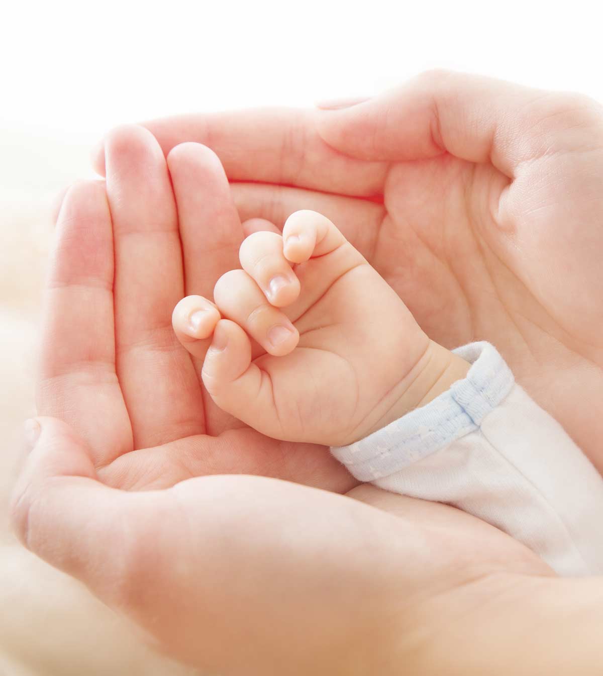 Frauenhände halten eine kleine Baby-Hand